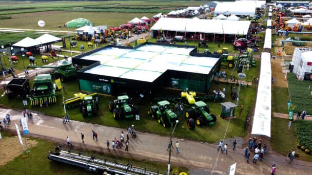 Vista aérea do estande da Agro Baggio (John Deere) montado pela LXBR no Show Safra 2025, com estrutura elevada e pátio de máquinas agrícolas.