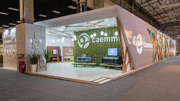 Estande de esquina da Caemmun com jardim vertical e letras 3D iluminadas, desenvolvido pela LXBR